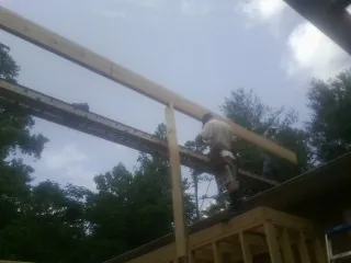 Carpenter setting a ridge beam over a new addition frame — Ice Dam Removal by Roofing Brothers in Imbler