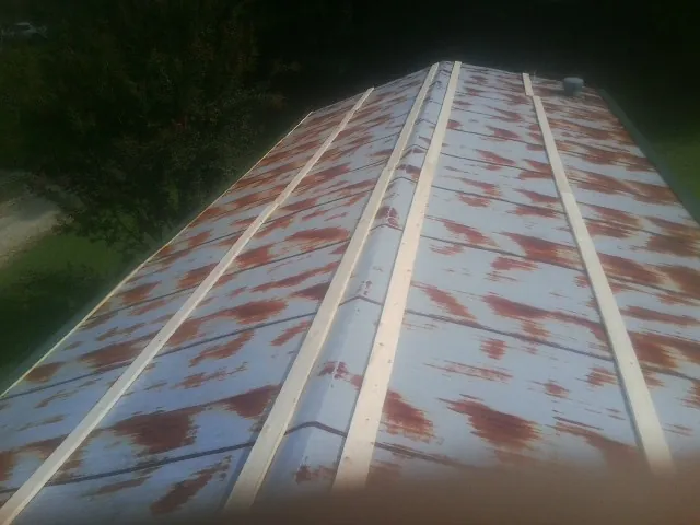 Rusted metal roof panels with new wood purlins before replacement — Storm Damage Roof Repair in Imbler by Roofing Brothers