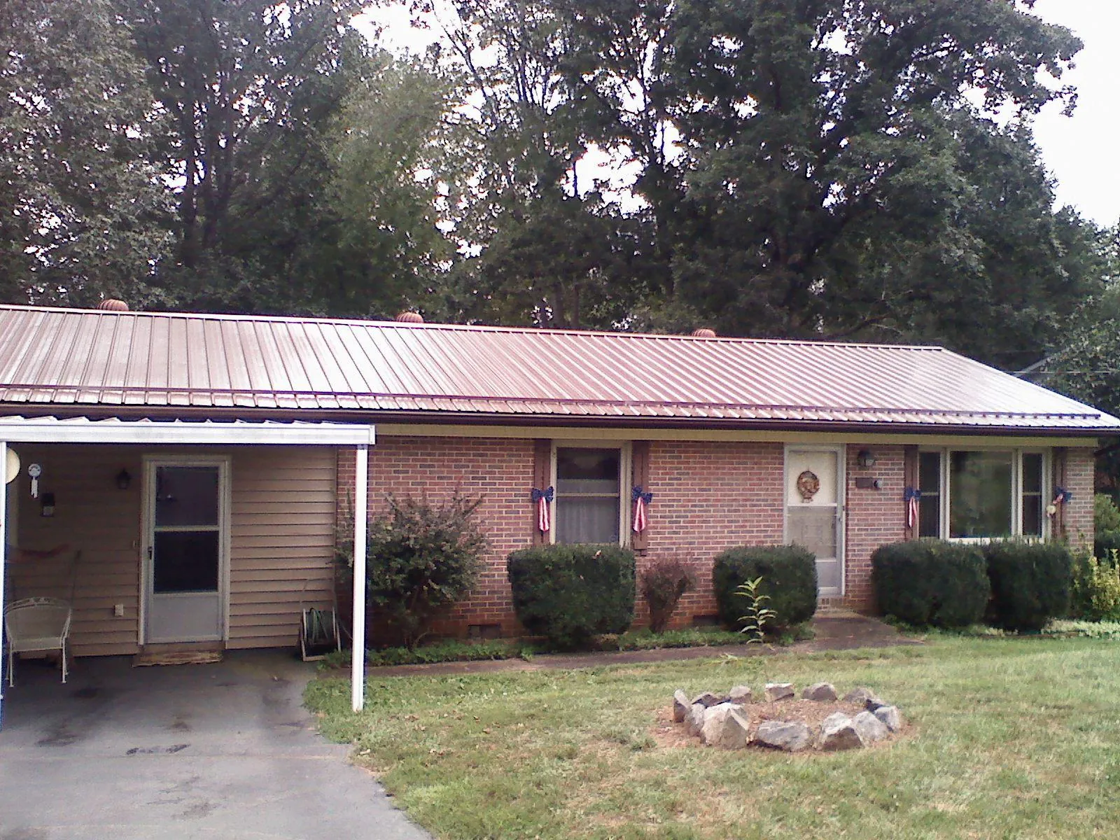 Bronze metal roof and carport on a brick ranch home — Roof Repair work by our crew in Imbler